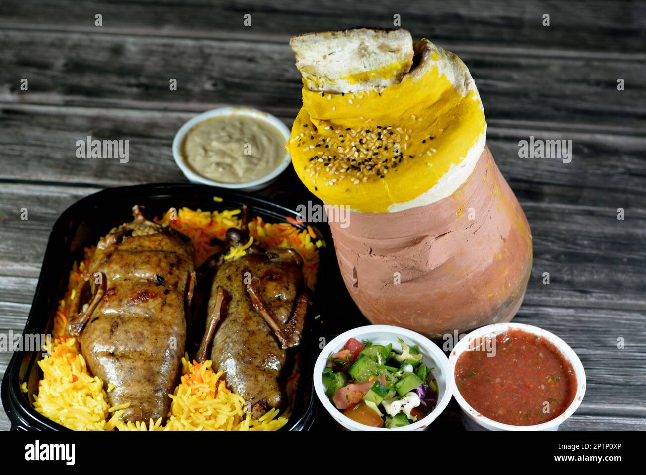 Background of Egyptian Hamam pigeons Mahshi stuffed squab with rice and A pottery hot pot covered with dough, sesame, lamb shank is inside it with Bas Stock Photo