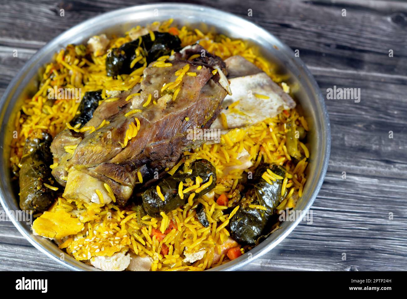 A well cooked lamb shank with yellow Basmati rice and mixed vegetables