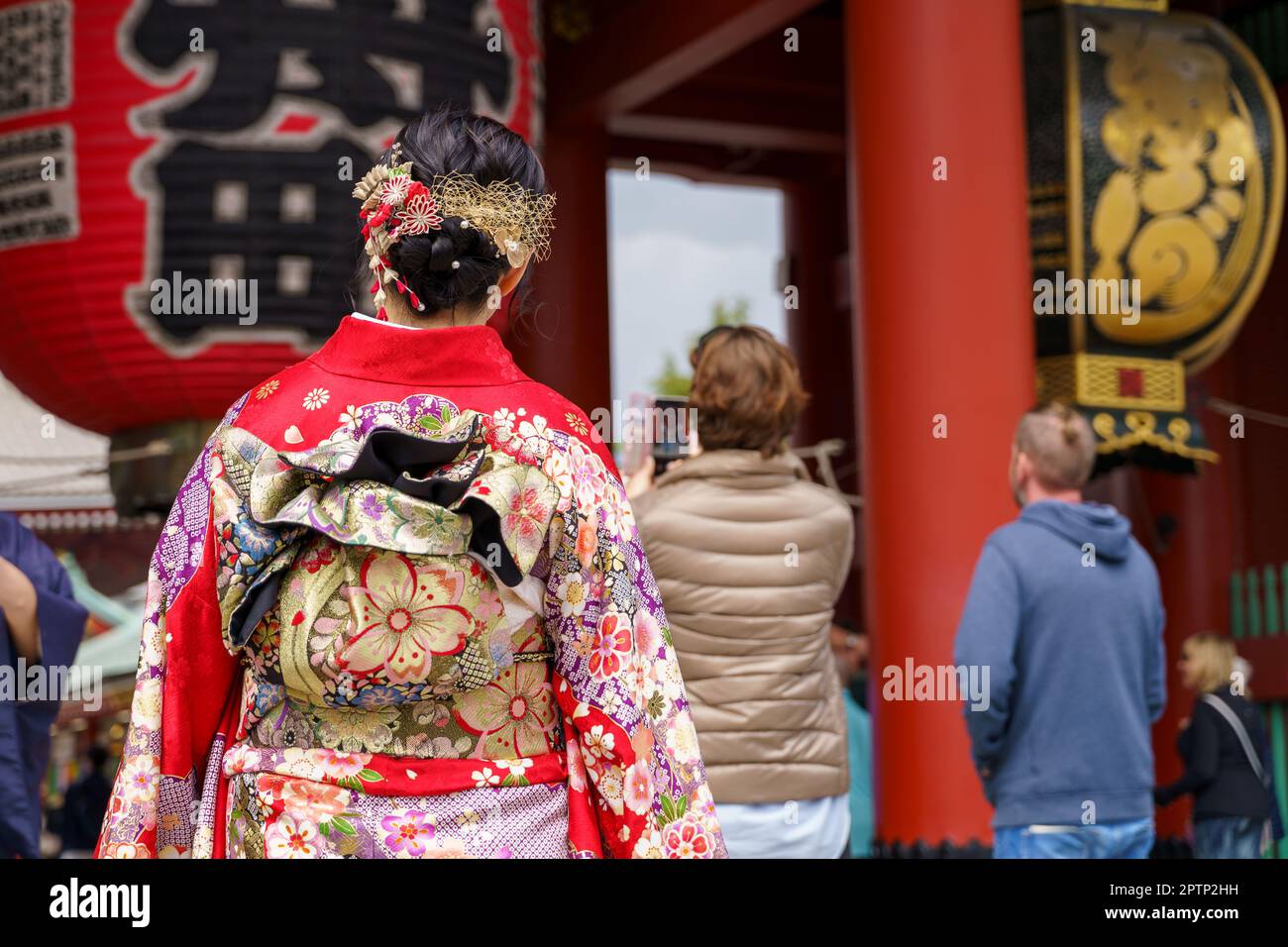 Young girl wearing Japanese kimono standing in front of Sensoji Temple
