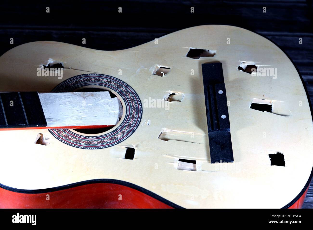 A broken wooden old classic guitar with damaged strings chords