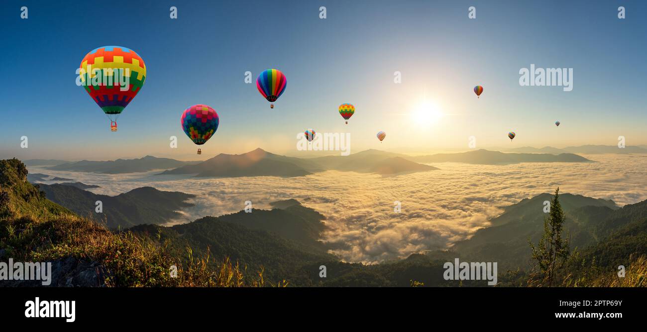 Colorful hot air balloons flying above mountain at sunrise sky background. Travel natural background. Stock Photo