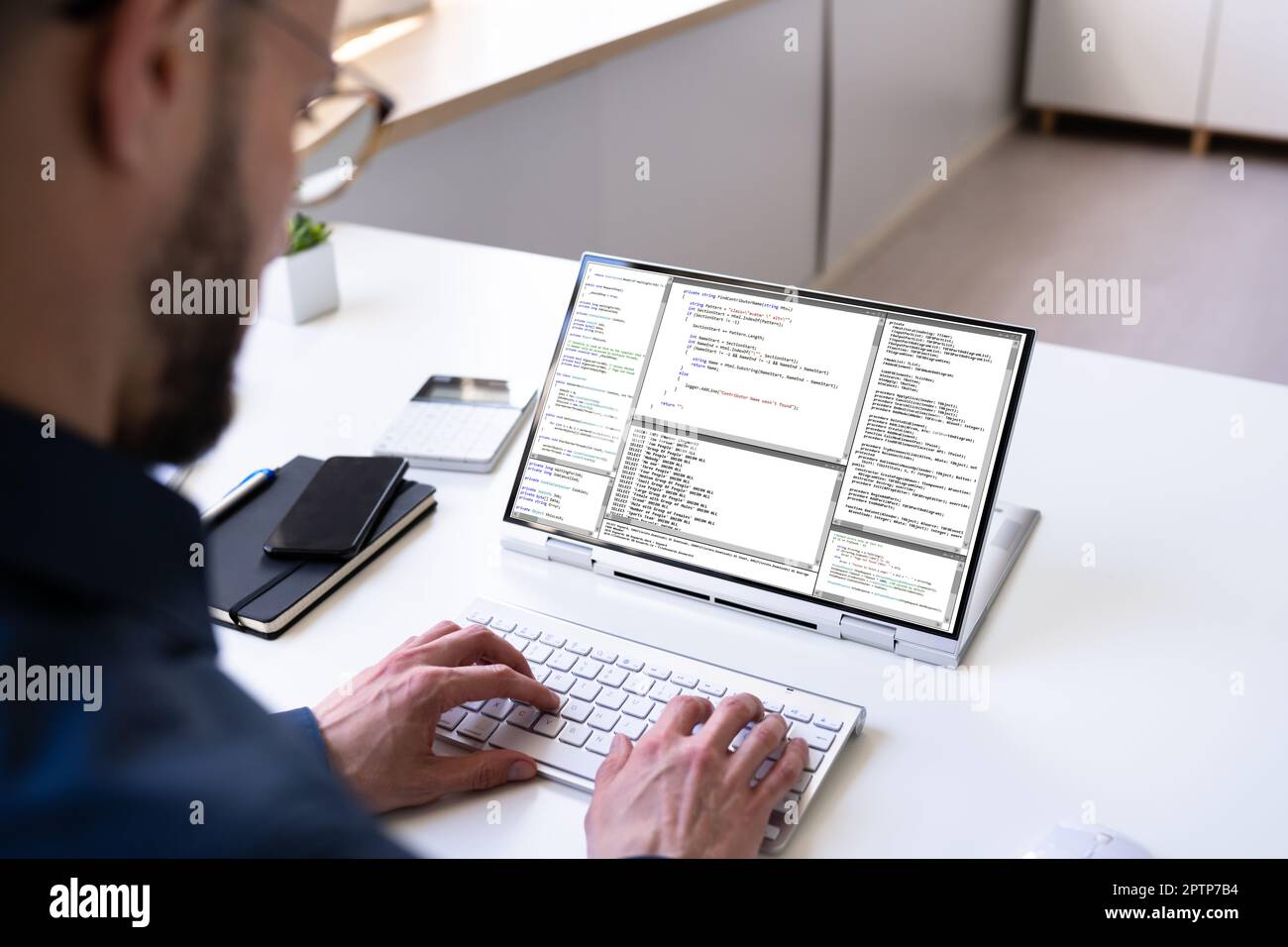 Programmer Or Coder At Office Desk Using Laptop Stock Photo