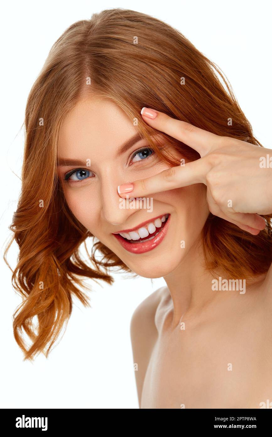 Beautiful young woman with blue eyes and red lips shows two fingers ...