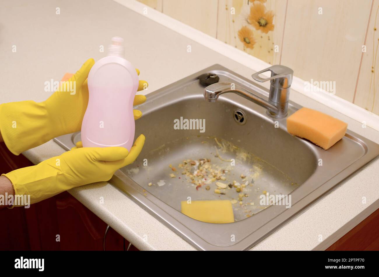 https://c8.alamy.com/comp/2PTPF70/people-housework-washing-up-and-housekeeping-concept-cleaner-shows-liquid-cleanser-detergent-bottle-at-dirty-kitchen-sink-with-food-particles-before-2PTPF70.jpg