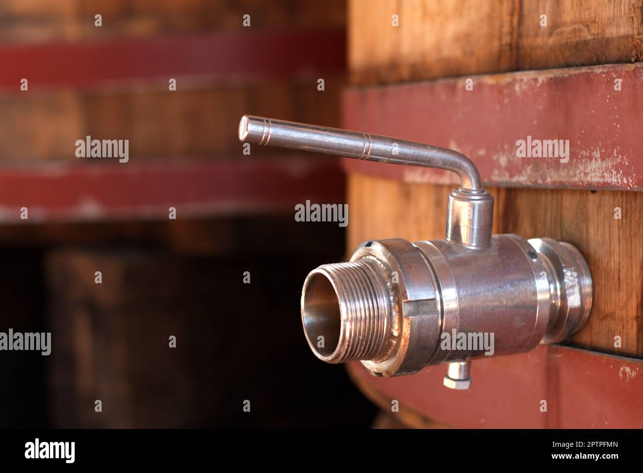 Old stainless steel disc valve on a wooden wine barrel. Stock Photo