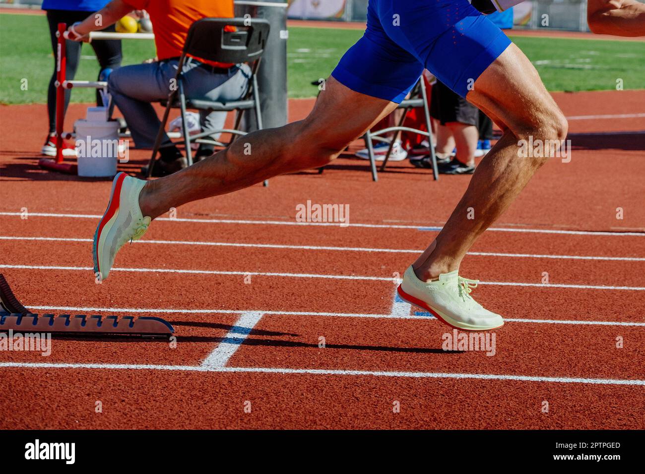 legs male athlete start running in starting blocks sprint race, summer