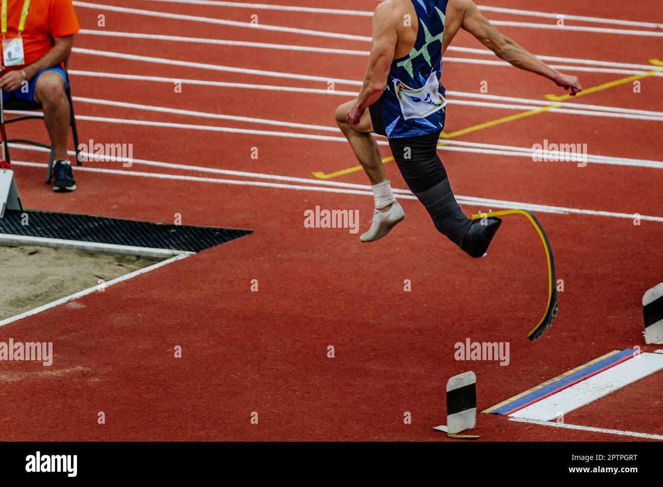 male para athlete on limb deficiency long jump take off board, summer