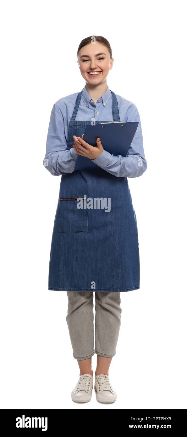 Beautiful young woman in clean denim apron with clipboard on white ...