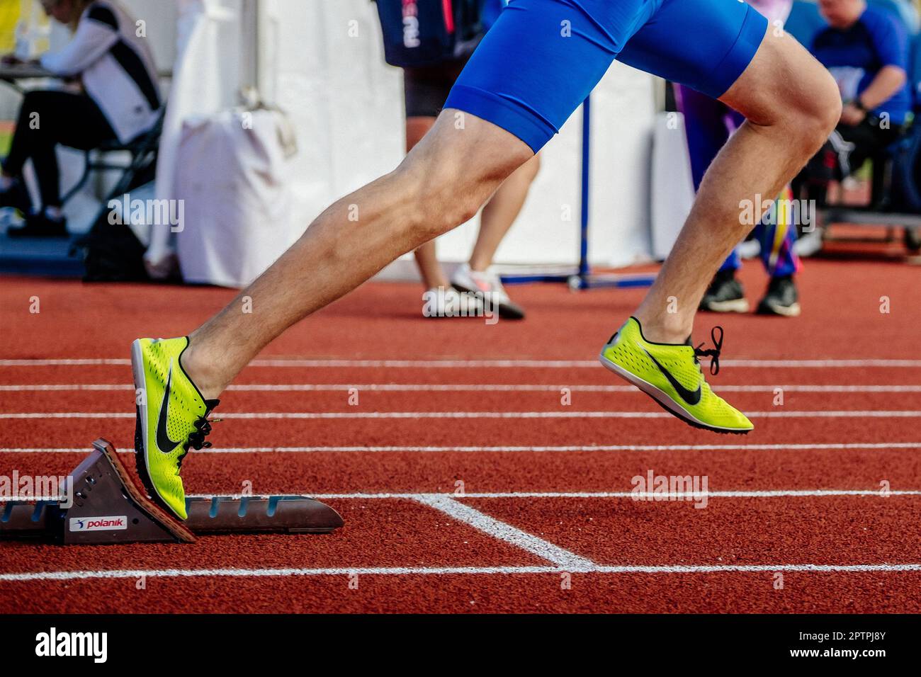 legs male athlete start running in Polanik starting blocks sprint race, Nike spikes shoes Stock Photo