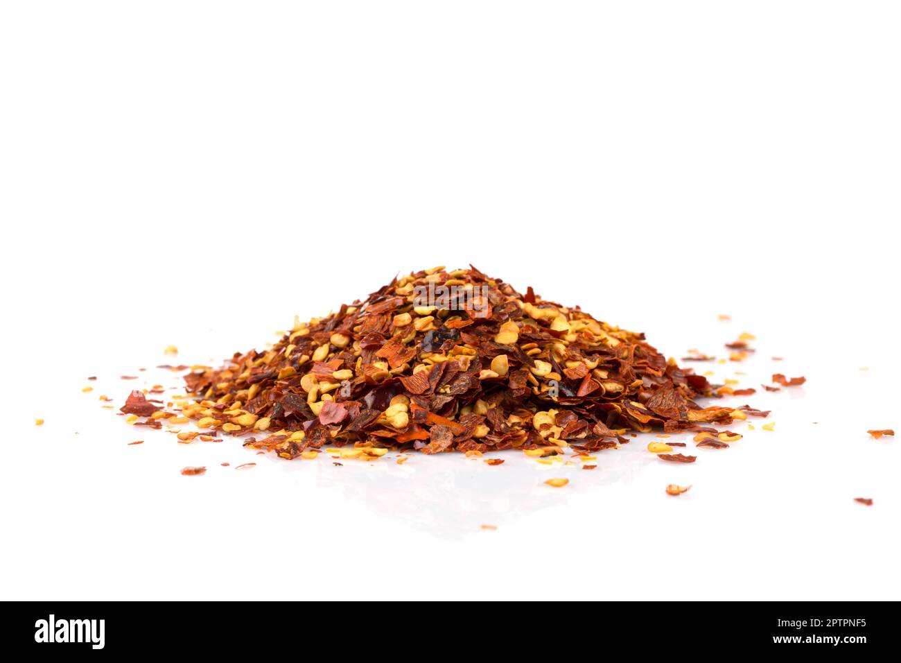 The pile of a crushed red pepper, dried chili flakes and seeds isolated