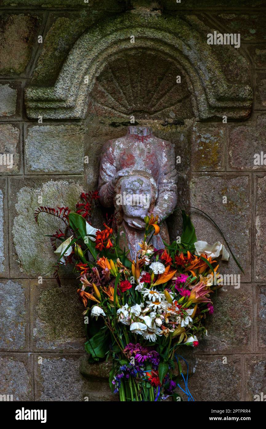 Statue of a Christian martyr holding her own head and splashed with red to represent her blood.  Shrine built in the 1500s AD at Noyal-Pontivy, Morbihan, Brittany, France, to honour Celtic Saint Noyal or Noyola. Stock Photo