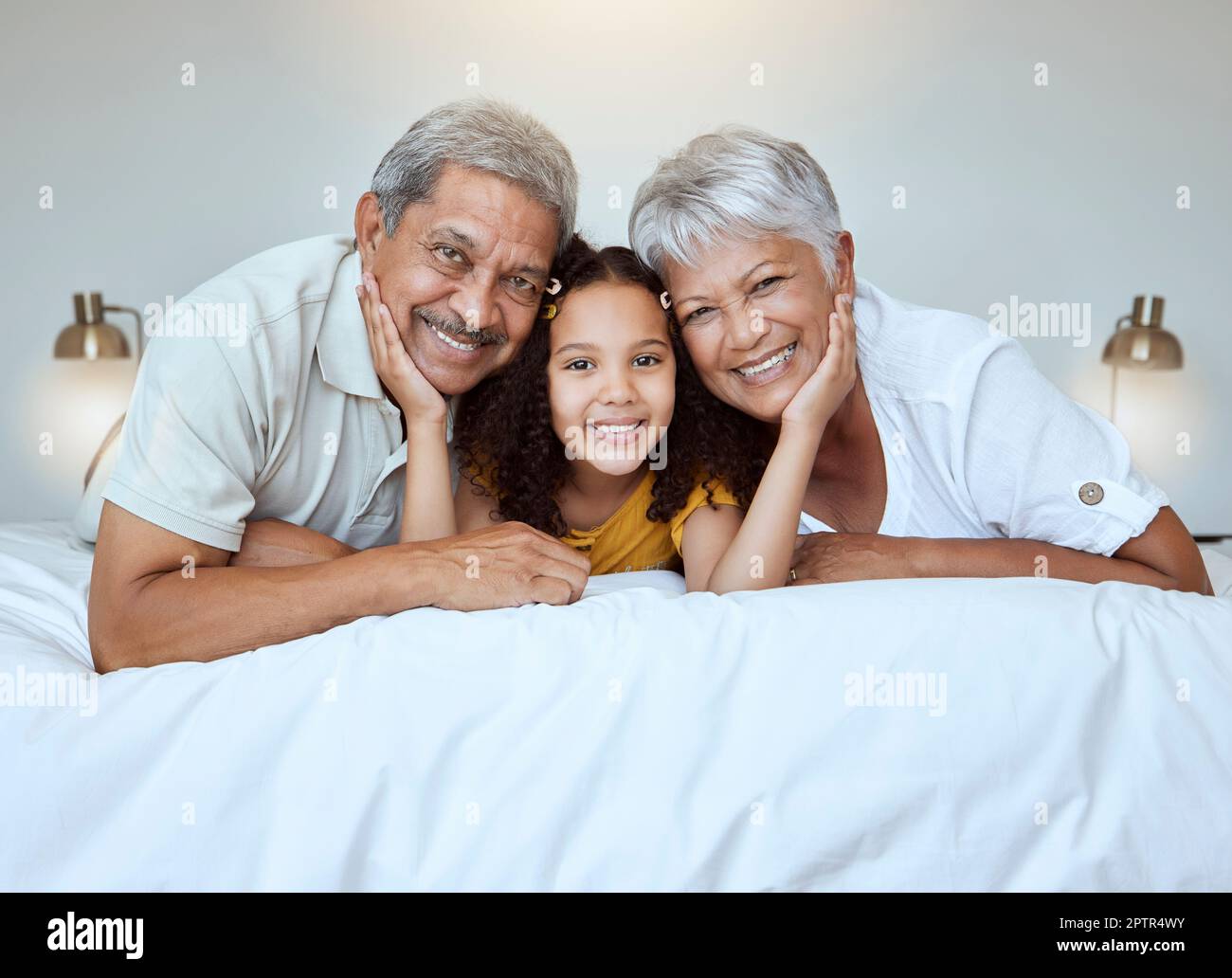 Girl, grandparents and smile on bed for portrait, together and bedroom for bonding, love and