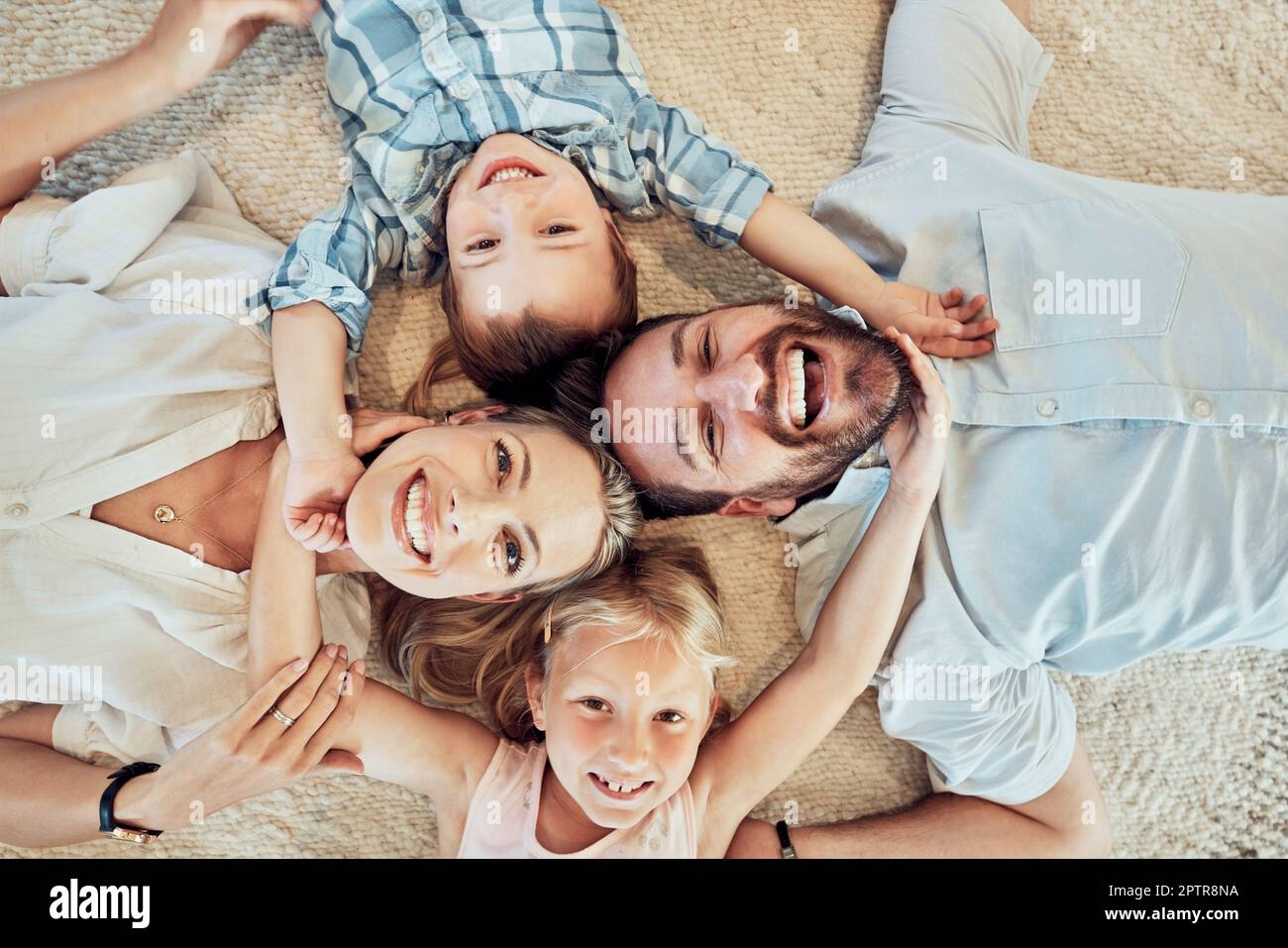 Above view of young family lying on the floor in a circle and taking