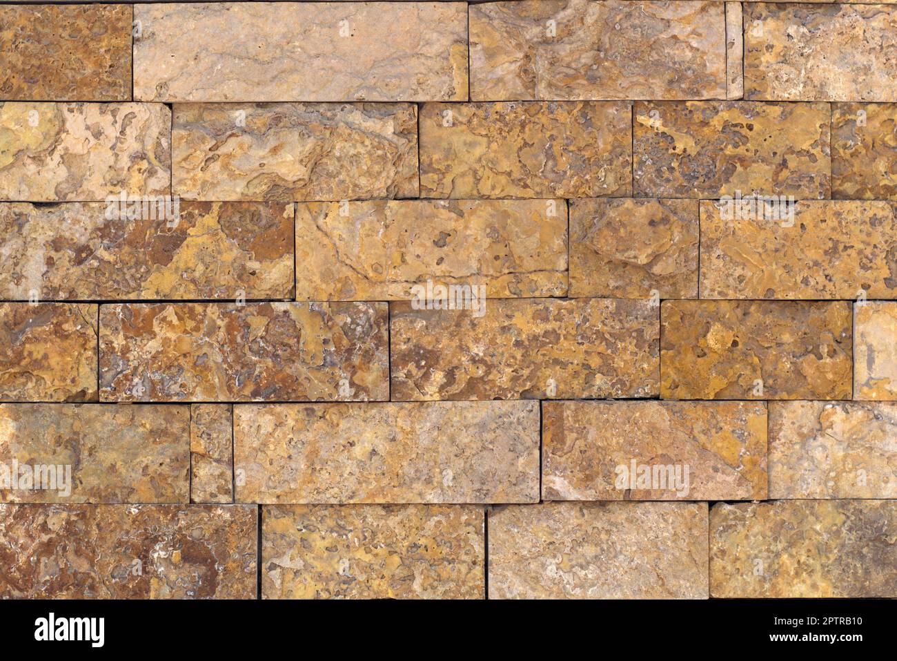 Rust-colored sandstone wall. Natural, rustic style construction. Stock Photo