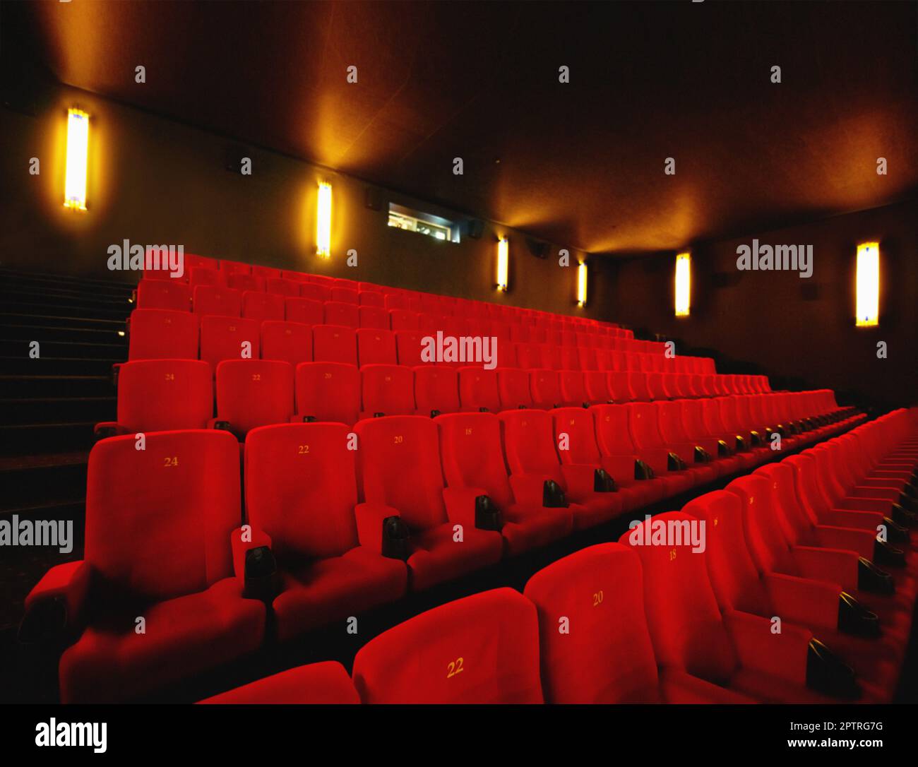 Empty cinema or movie theatre with row of red seats at night before a