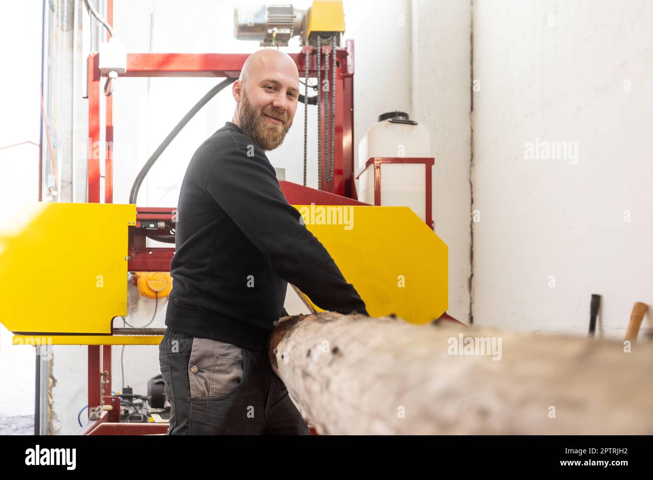 Young joiner cutting huge wood on the band saw, joinery concept Stock Photo Alamy