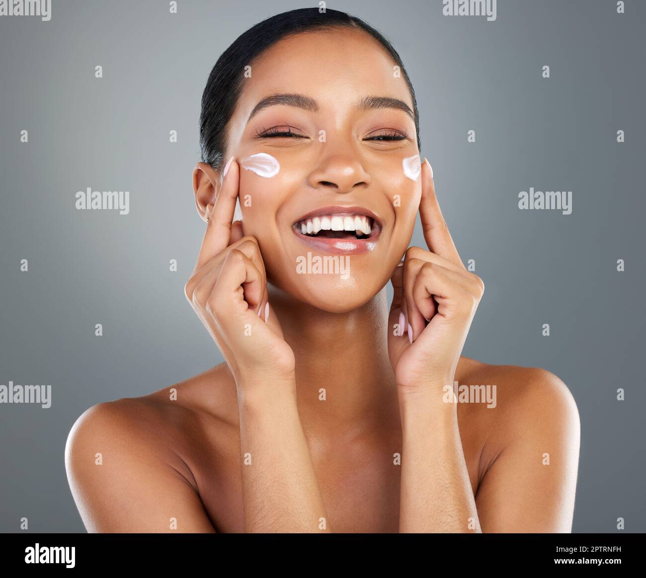 These rosy cheeks stay moisturised. a beautiful young woman applying