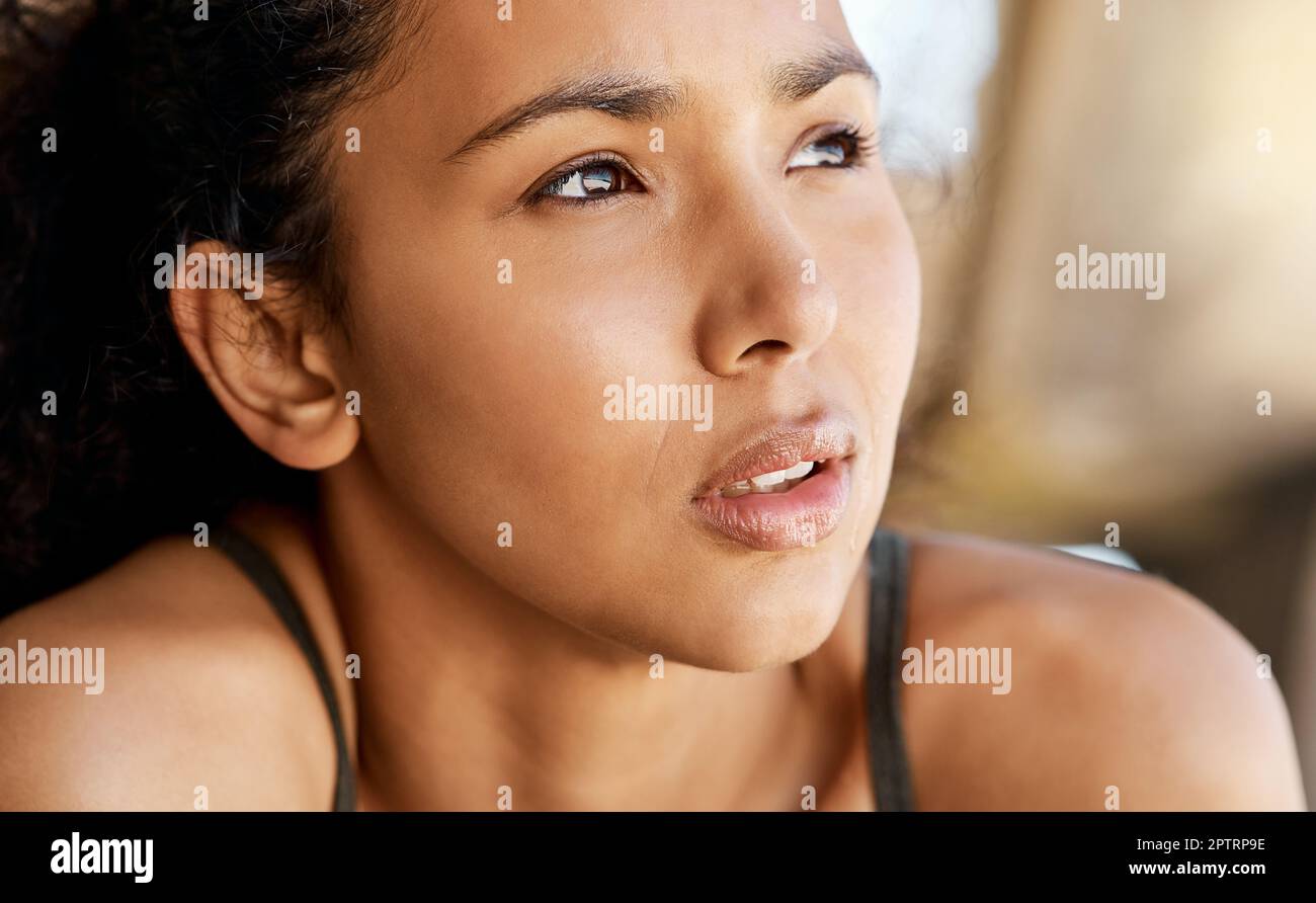 I can see my goal in plain sight. an attractive young woman taking a moment to catch her breath during her outdoor workout Stock Photo
