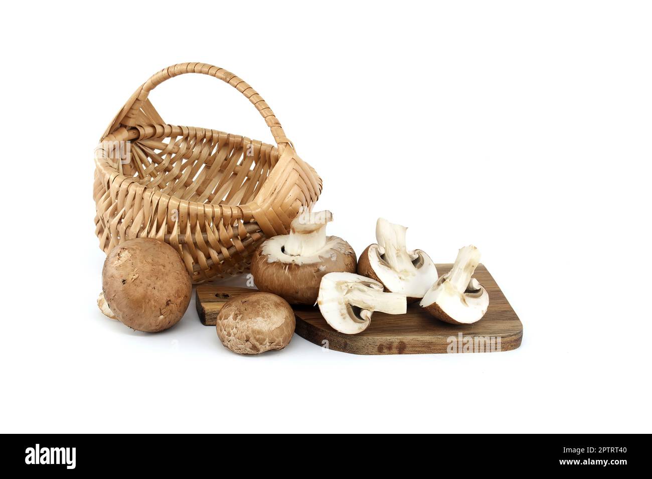 Fresh Baby Bella or Cremini whole mushrooms in front of wicker basket isolated on white