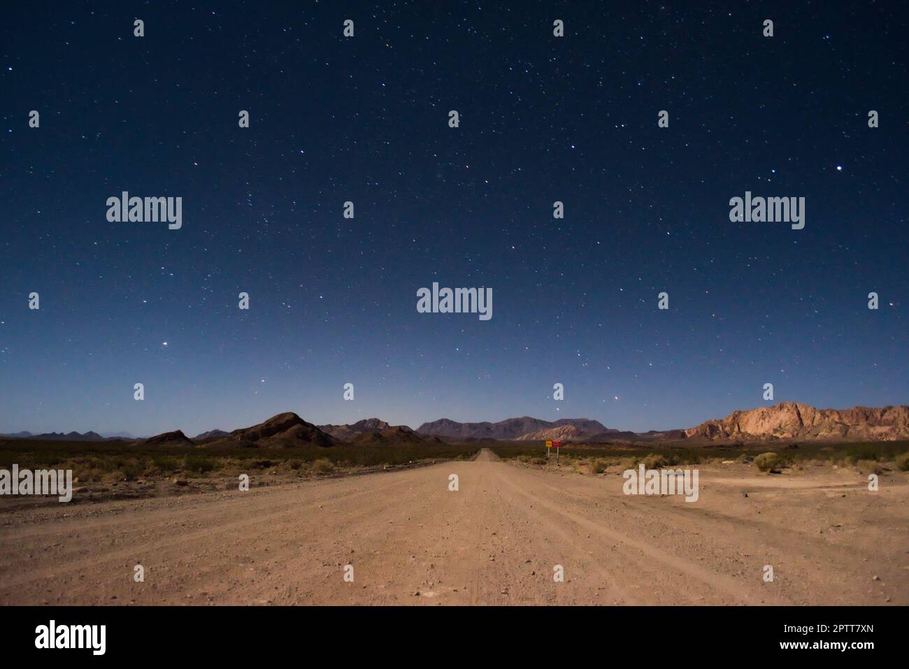 Starry night sky above a dirt road across the desert near Uspallata ...