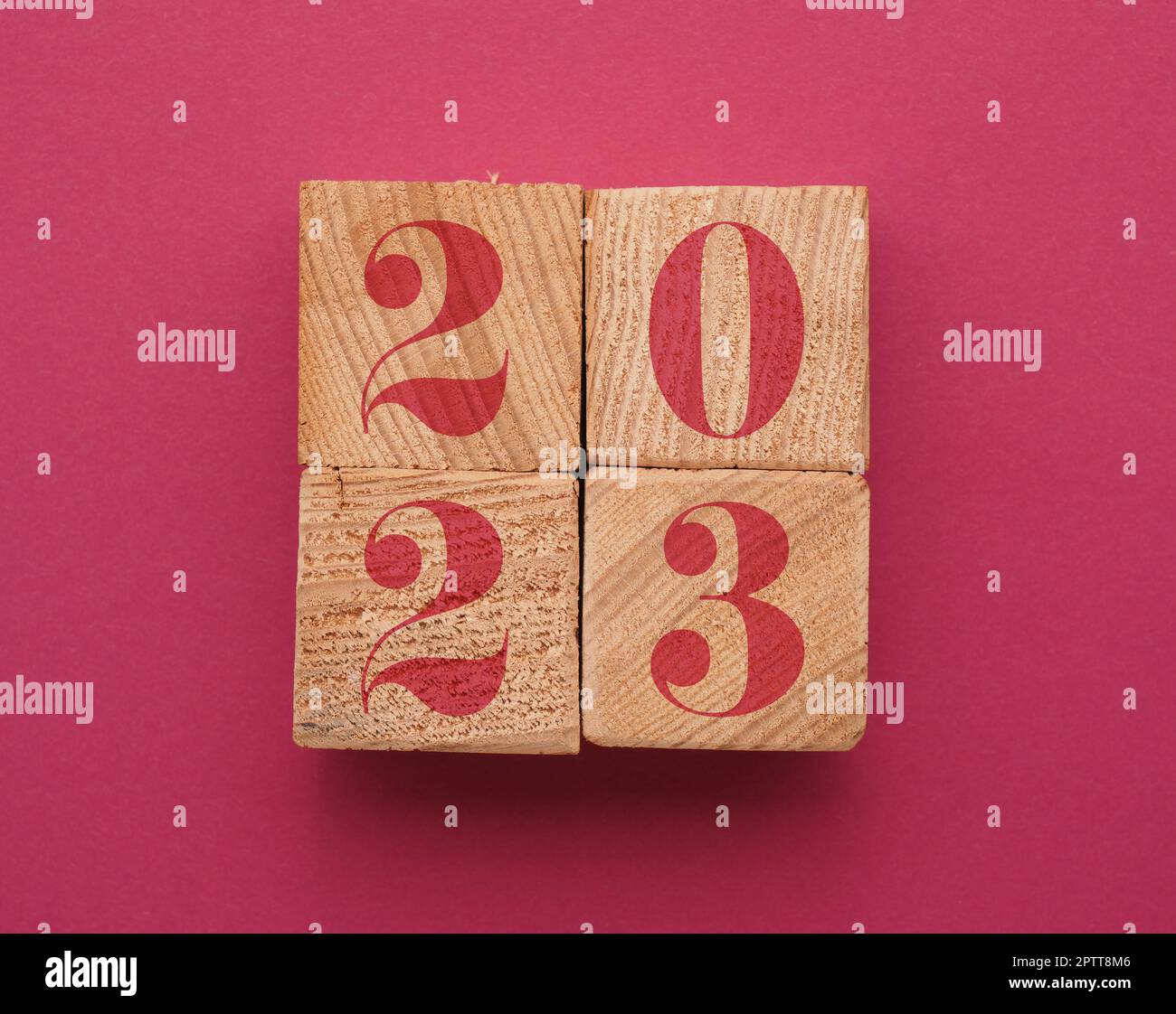 Wooden blocks with the Year number 2023 on a magenta paper sheet, color of the year 2023 conceptbackground Stock Photo