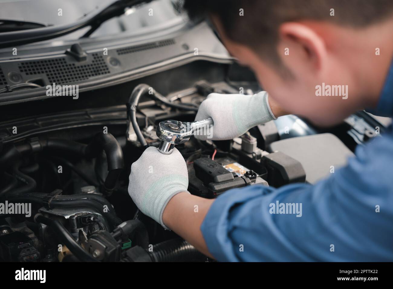 Service outdoor. Asian auto mechanic man working on car engine using