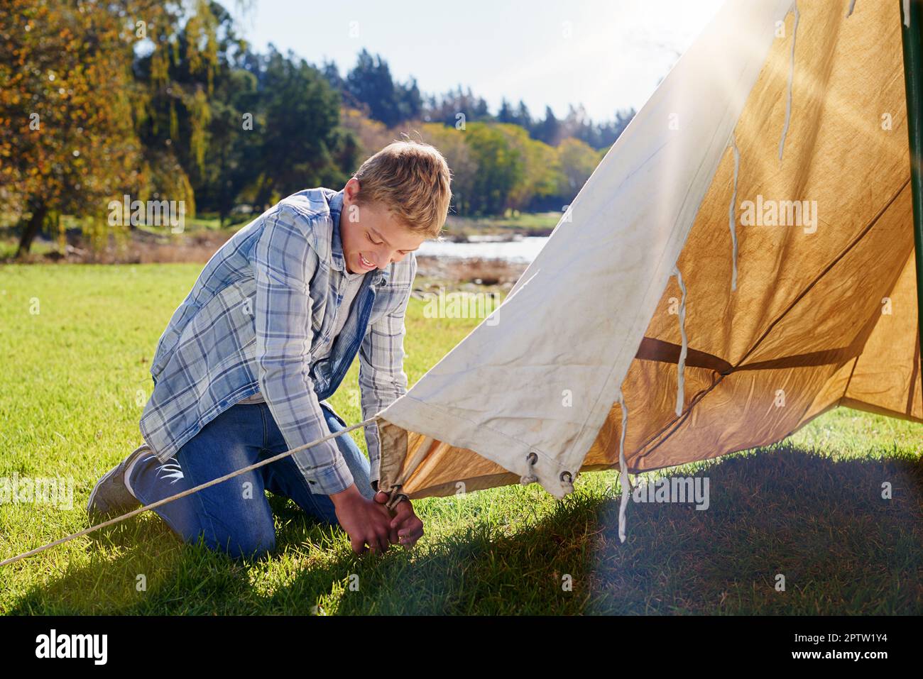 Hes found the ideal camping spot. a young boy putting up his tent on a  camping trip Stock Photo - Alamy