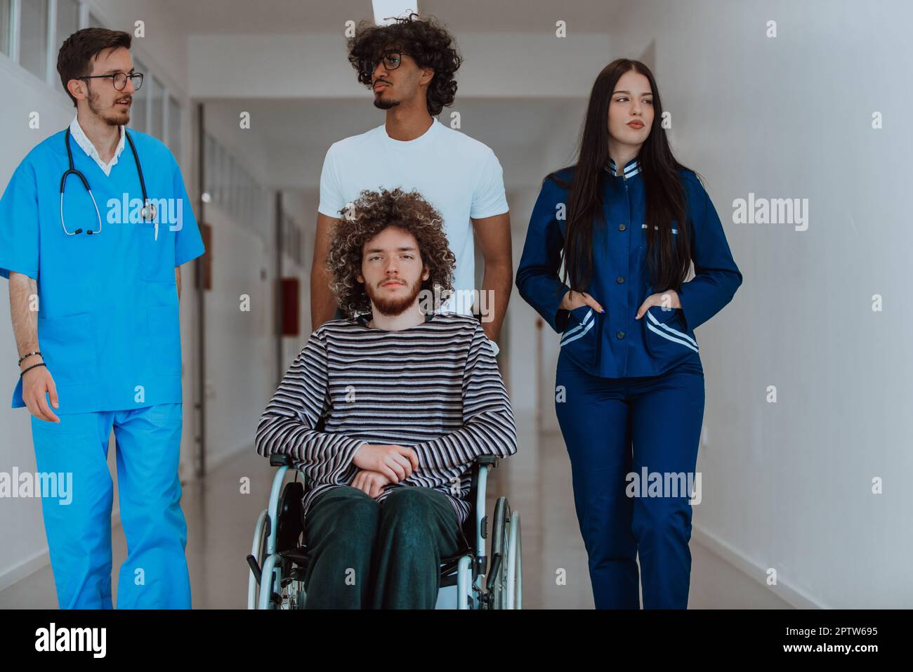 Two doctors and a nurse walking down a hospital hallway, pushing a ...