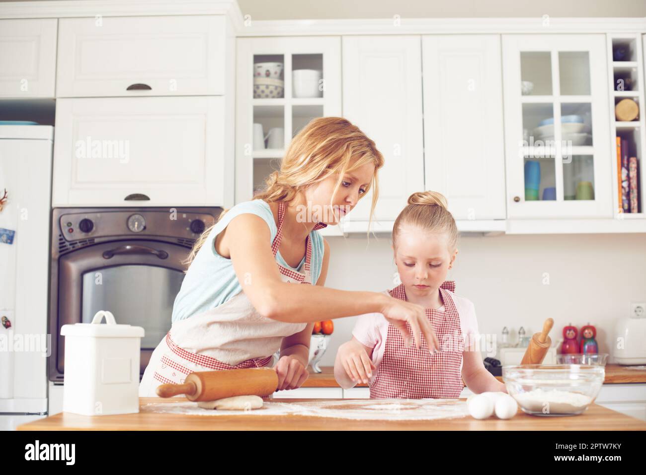 Teaching her the basics of baking. Cute little girl baking in the ...