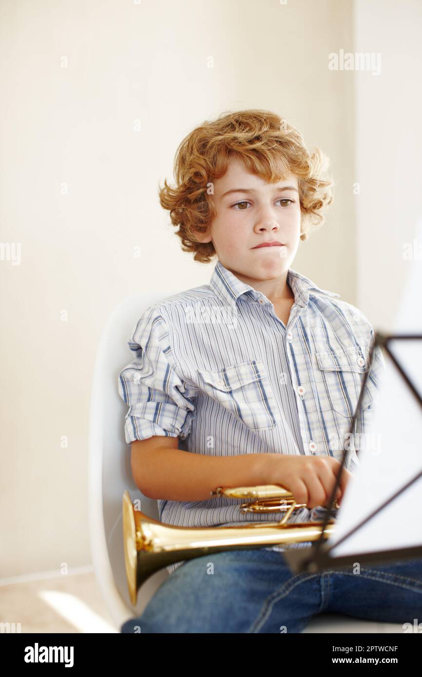 Hes the cutest trumpet player. a cute little boy playing the trumpet Stock Photo Alamy