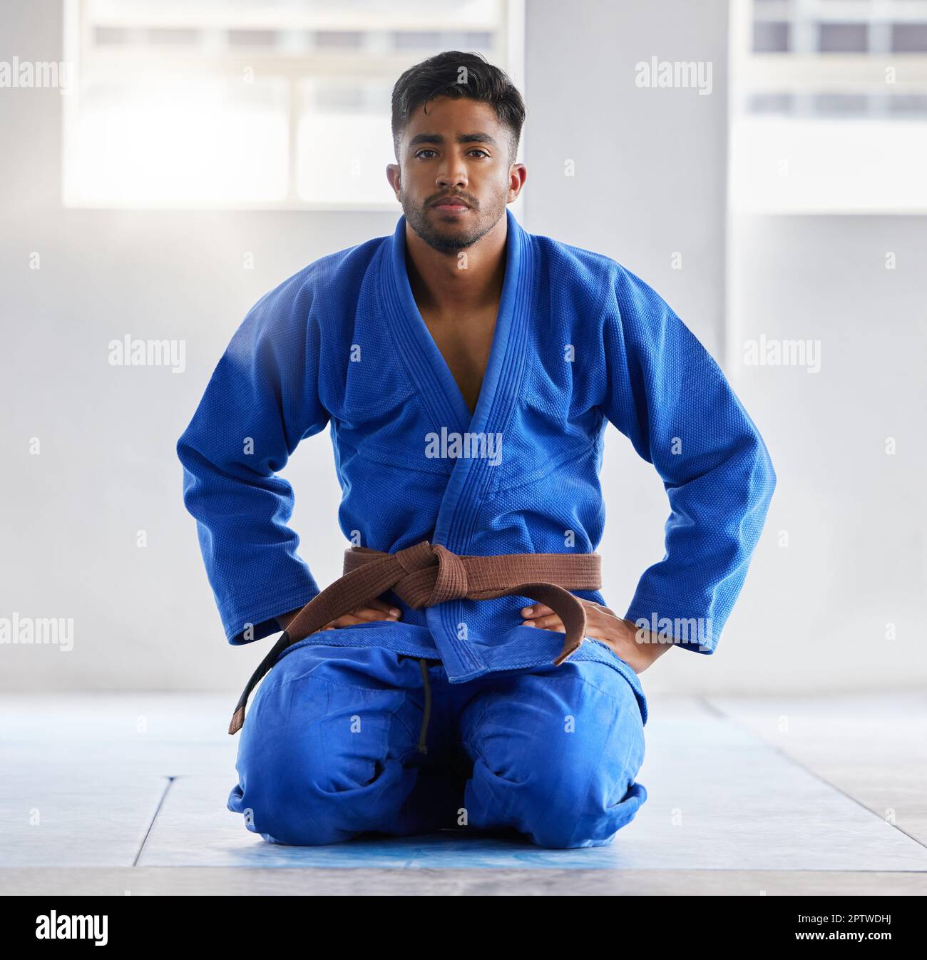 Karate, training and portrait of a coach ready for martial arts, fight and self defense sport at a gym. Fitness, focus and man in a uniform with a bro Stock Photo