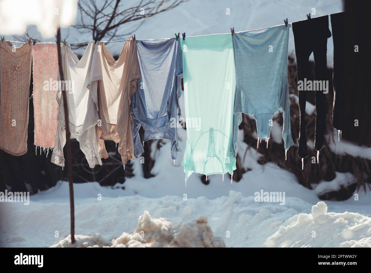 washed clothes hang on a string in the cold, hardened Stock Photo