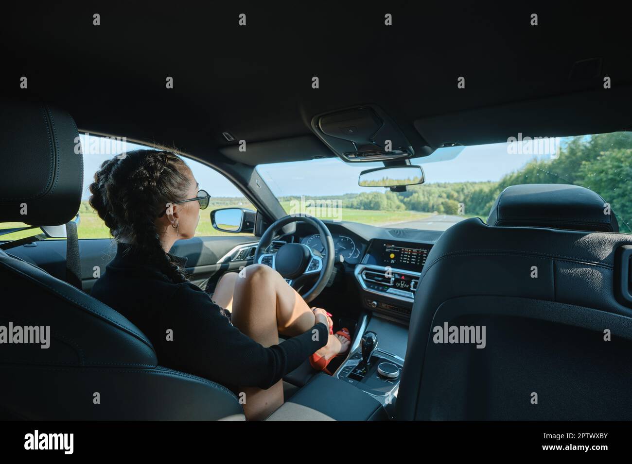 Pretty woman sitting behind the steering wheel in powerful car Stock ...