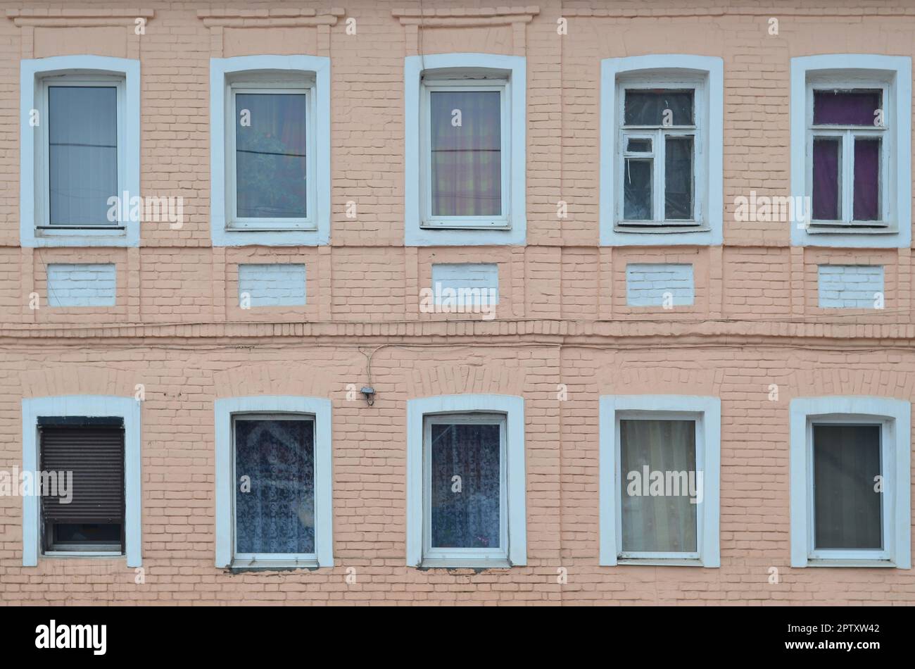 The texture of a brick wall with a few windows. Glazed windows in the ...