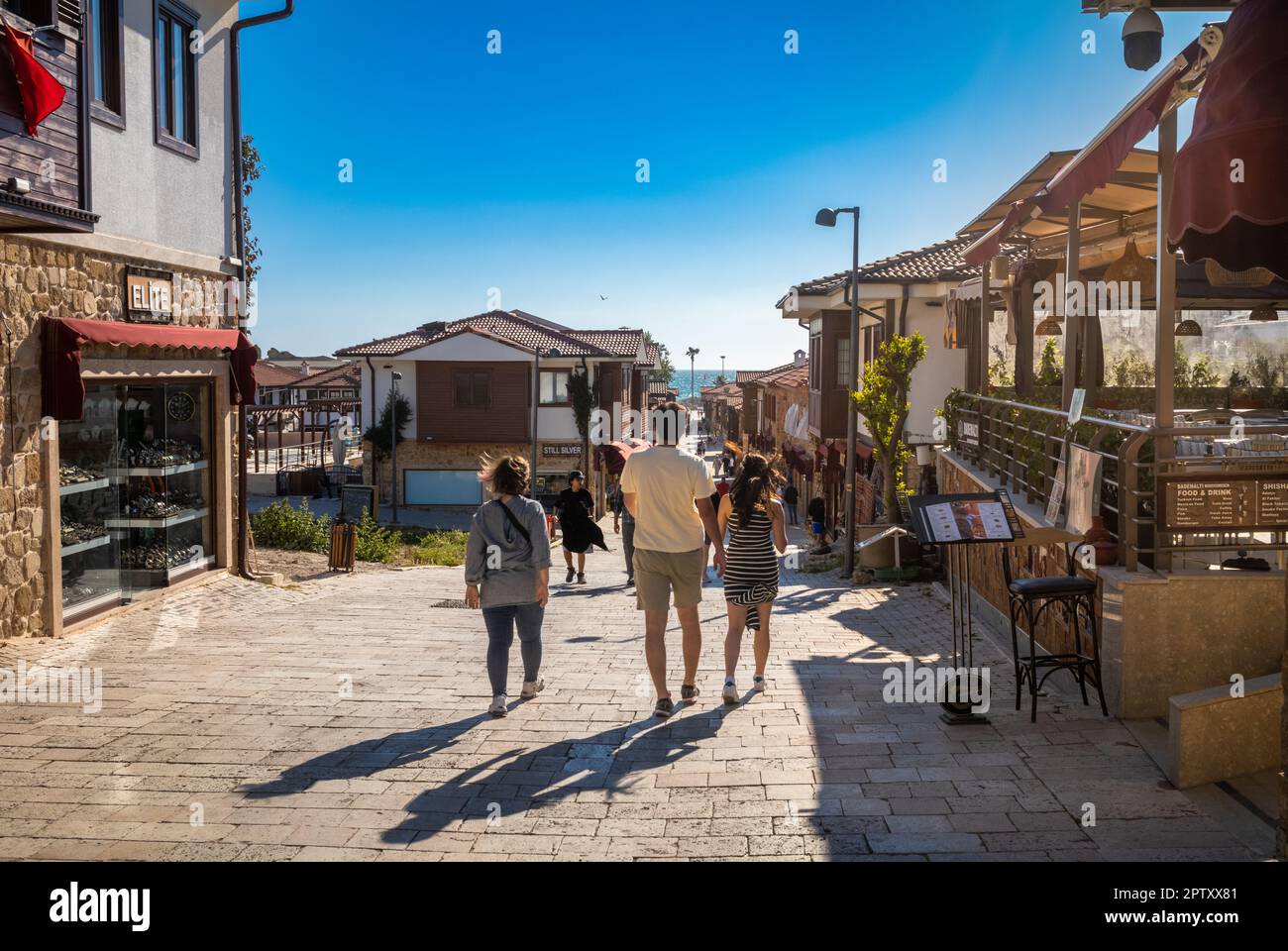 Tourists walk in Liman St in Side Old Town in Antalya Province, Turkey (Turkiye). Side is the site of an ancient Roman city and a popular cultural and Stock Photo