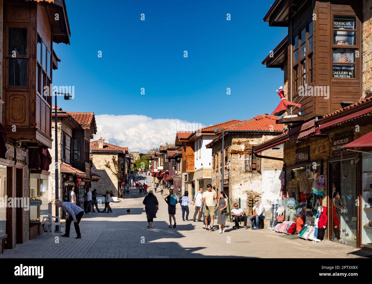 Tourists browse shops and locals chat in Liman St in Side Old Town in Antalya Province, Turkey (Turkiye). Side is the site of an ancient Roman city an Stock Photo