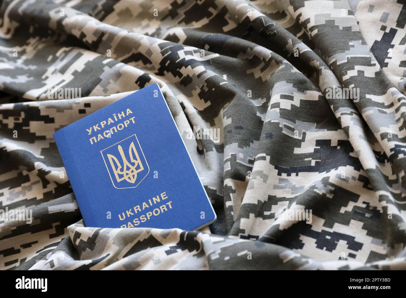 Ukrainian foreign passport on fabric with texture of military pixeled