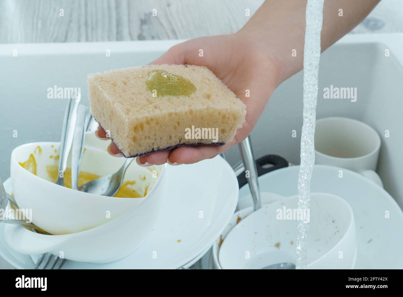 A pink viscose dish cloth rests on top of the kitchen faucet. Metal sink  with foam. Cleaning, washing dishes, household chores. Close-up, selective  fo Stock Photo - Alamy