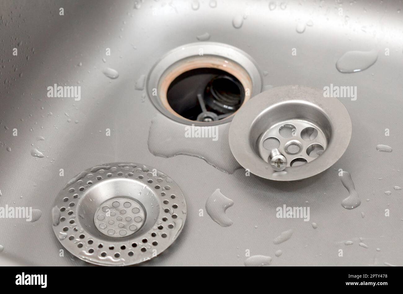 Silvery kitchen sink with a disassembled protective filter. Kitchen sink repair process Stock