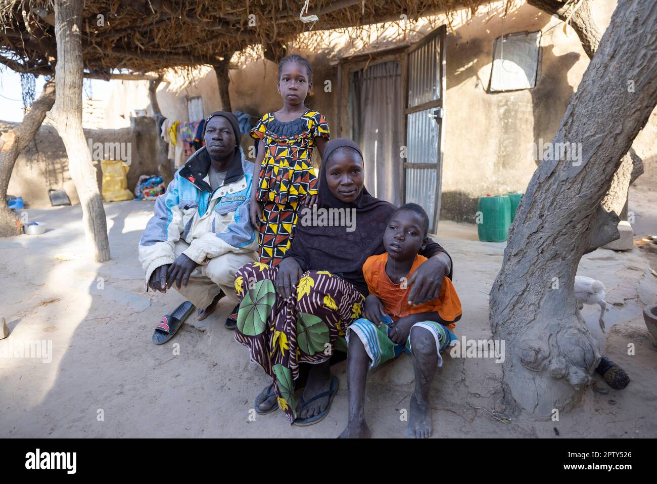 Large family sitting together in front of their home in Segou Region, Mali, West Africa. 2022 Mali drought and hunger crisis. Stock Photo