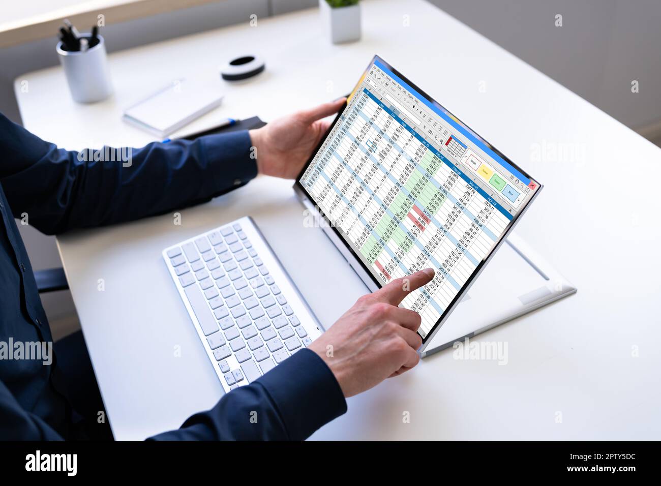 Electronic Spreadsheet Analyst Or Auditor Using Software On Hybrid Laptop Stock Photo