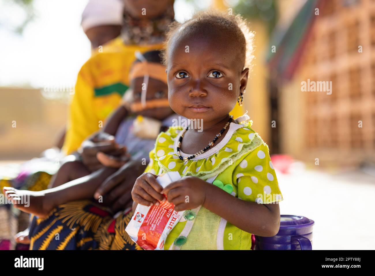 Child eating the theraputic food Plumpy'Nut while in hospital for malnutrition in Segou Region, Mali, West Africa. 2022 Mali drought and hunger crisis. Stock Photo