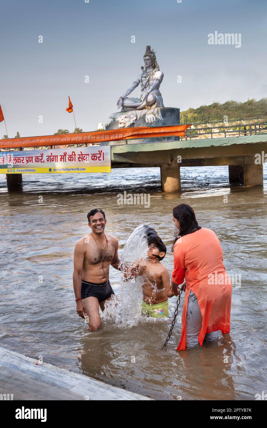 India, Uttarakhand, Rishikesh, Ganga, Ganges river. Parmath Niketan temple and complex. Shiva statue. Ritual cleaning of the body in the Ganges river. Stock Photo