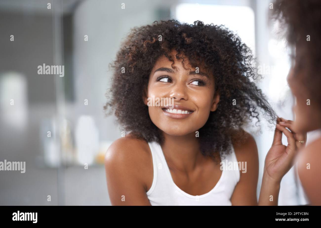 Having a good hair day. an attractive young woman taking care of her