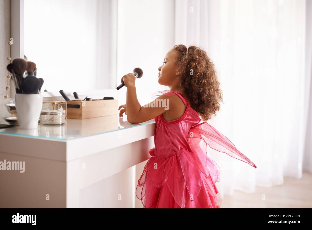 Im gonna look just like my mommy. a little girl applying blusher in the mirror Stock Photo