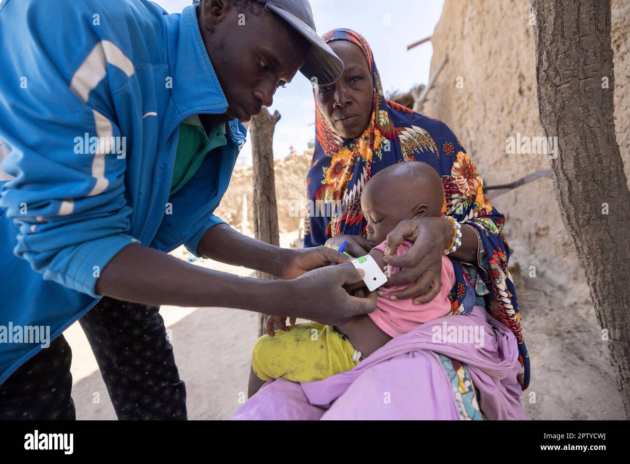 A health care worker measures the upper-arm circumference of a young child to measure nutrition levels in Segou Region, Mali, West Africa. 2022 Mali drought and hunger crisis. Stock Photo