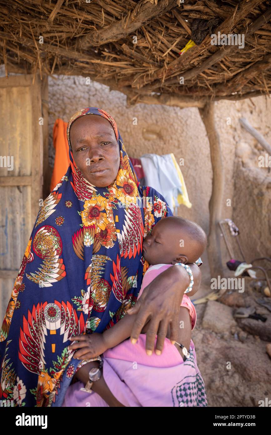 An elderly woman holds her sleeping grandson in Segou Region, Mali, West Africa. 2022 Mali drought and hunger crisis. Stock Photo
