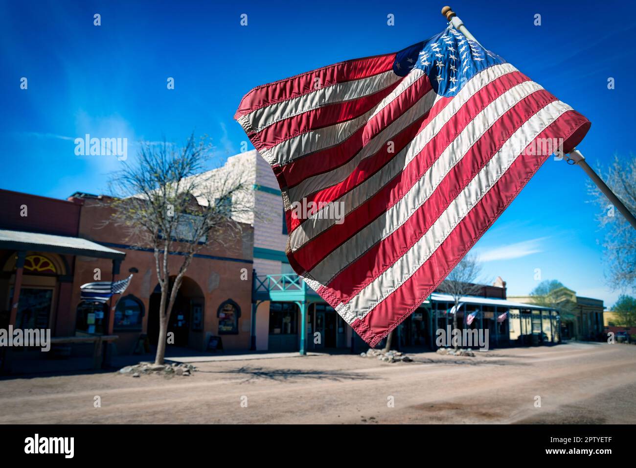 An American flag flies a historic street in Tombstone, Arizona. Stock Photo