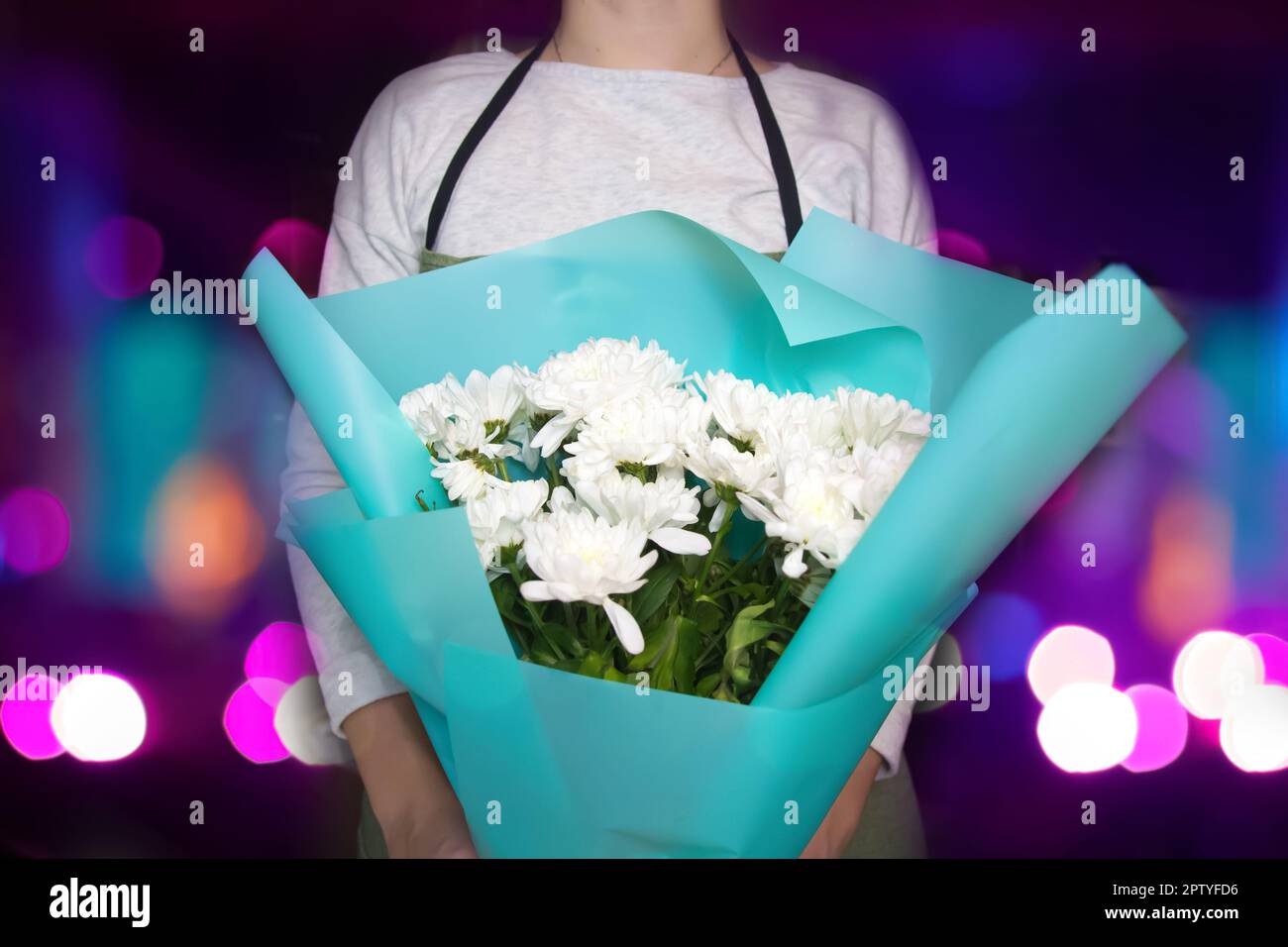 Female florist in a flower shop. Woman wrapping bouquet white da Stock Photo