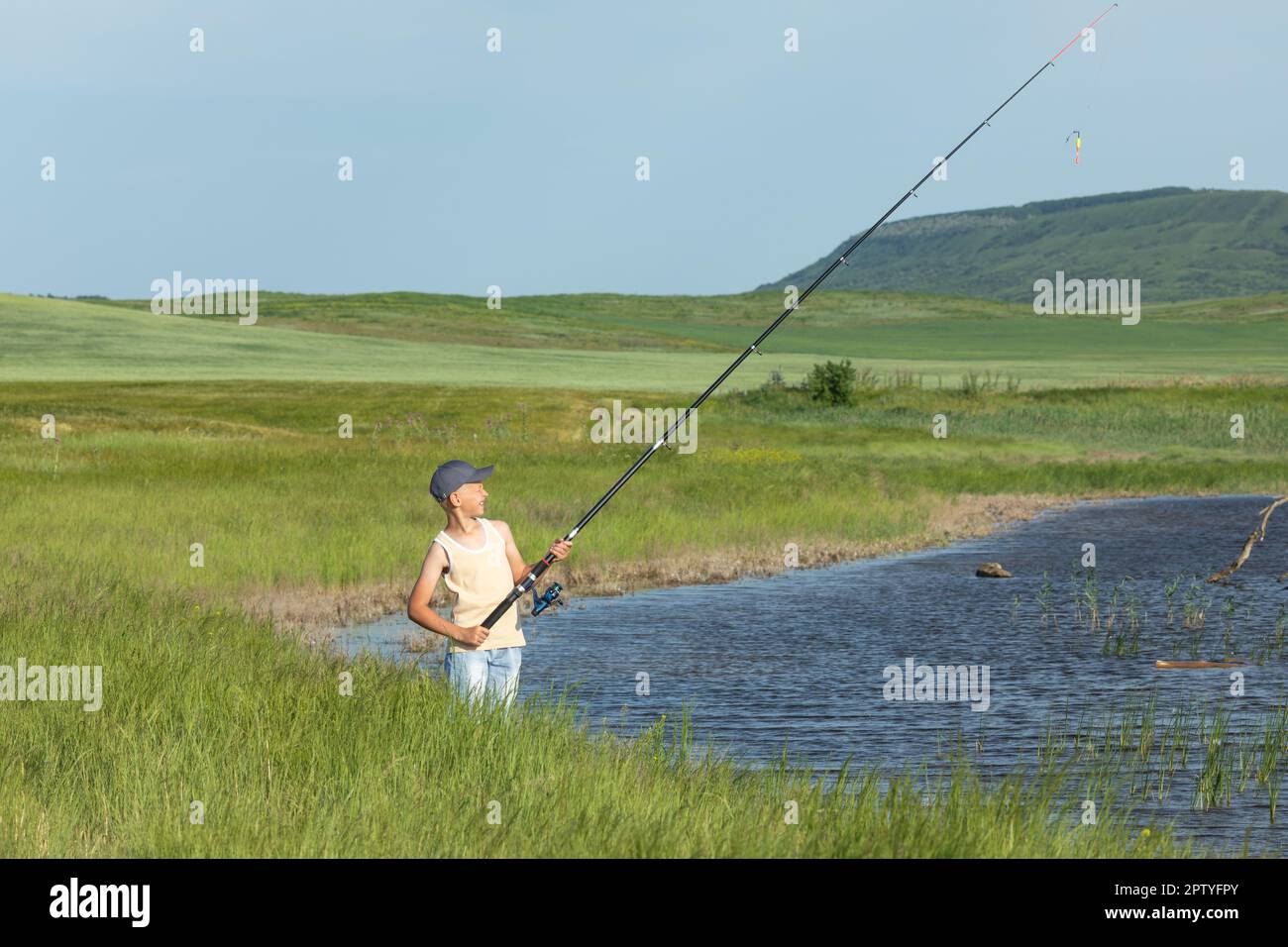 Cheerful boy wearing raincoat holding fishing net Stock Photo - Alamy